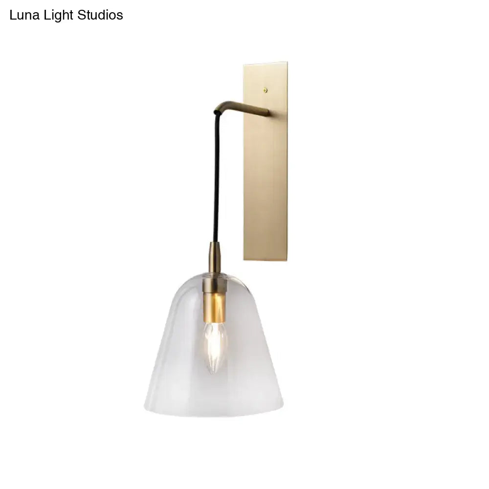 A retro style brass wall light with frosted glass bell shade and e14 bulb base bedroom sconce