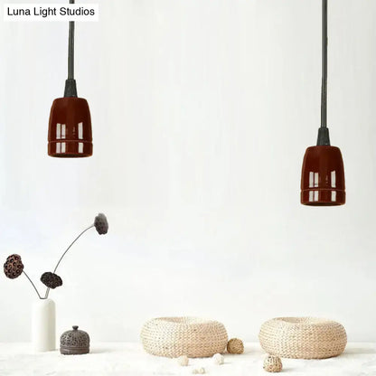 Two decorbites™ retro style pendant lights with glossy black red ceramic shades and adjustable cords hanging from ceiling