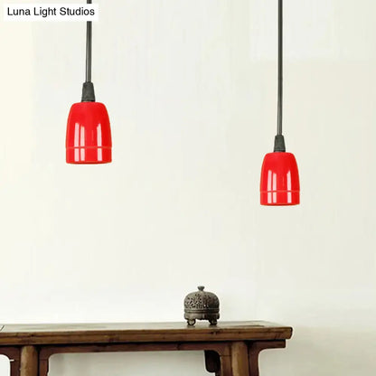 Two vibrant red ceramic ceiling pendant lights with glossy black red ceramic shades and adjustable cords hanging