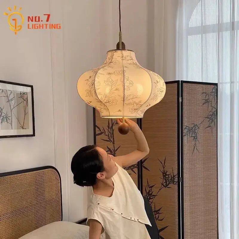 A cream fabric retro pendant light with floral embroidery and brass frame by decorbites wabi-sabi for bedroom decor
