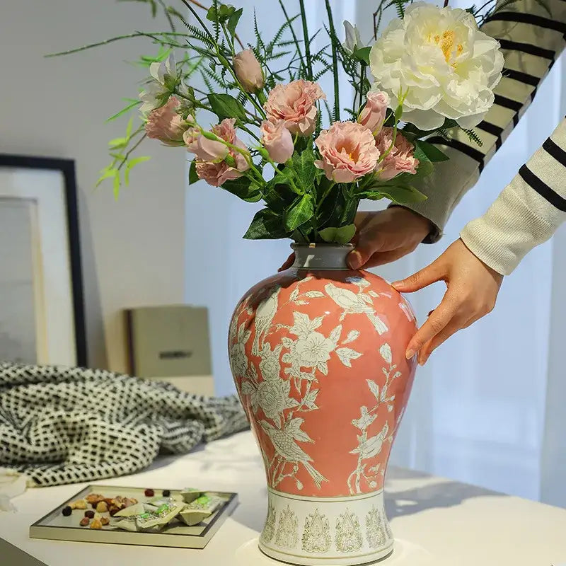A coral-pink ceramic vase with intricate white porcelain vase patterns on a decorative base for living room decorbites blue white style