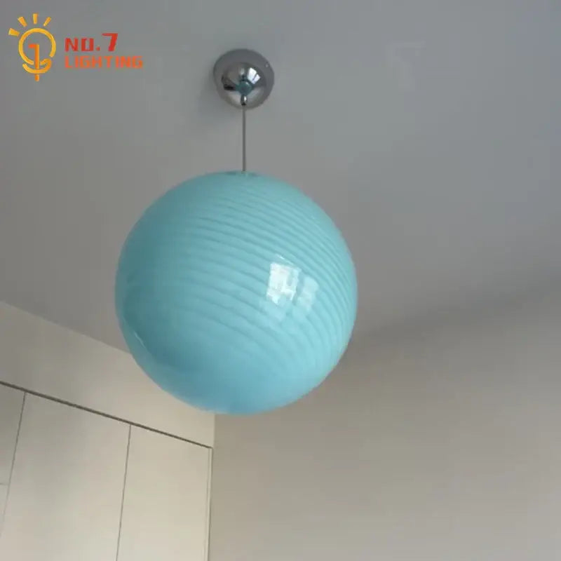 A sleek light blue glass pendant light with glossy finish and subtle ridges ideal for dining room pendant lights