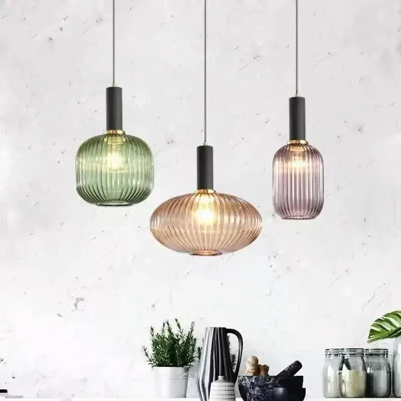 Three modern pendant lights with ribbed amber, green, and mauve glass shades for dining room decorbites colorful glass pendant lighting