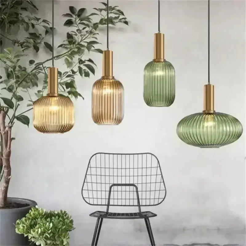 Set of four ribbed amber and sage green colorful glass pendant lights with brushed brass fixtures for dining room decorbites decor