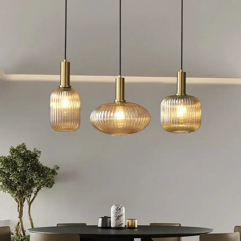 Three elegant ribbed amber glass pendant lights with brass finish enhance modern dining room decorbites colorful glass