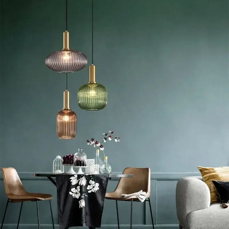 Three colorful glass pendant lights with ribbed shades in amber purple and green for dining room decorbites lighting