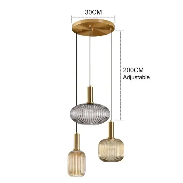 Modern three-light pendant lights with brass fixtures and ribbed amber, gray, and gold textured glass for dining room decorbites colorful glass pendant
