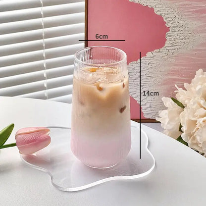 A tall ribbed decorbites clear glass coffee cup holds a pink iced beverage in a clear glass kitchen tumbler set