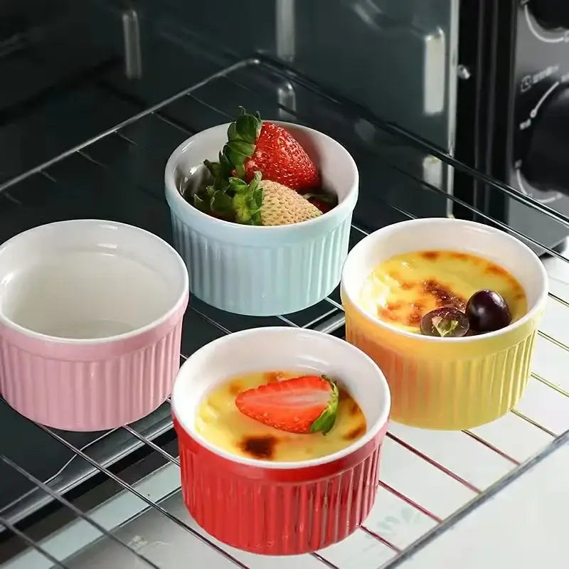 Set of four colorful ribbed decorbites ceramic baking bowls in pink light blue yellow and red for kitchen use