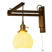 Warm yellow ribbed glass wall sconce with brass fittings and walnut arm for decorbites ceramic led wall lighting