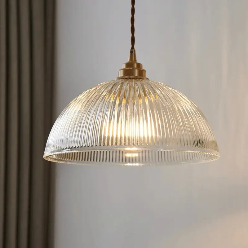 A warm-toned ribbed glass chandelier pendant light with brass finish and twisted cord for bedroom pendant lights