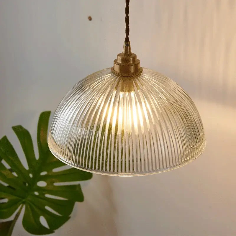 A warm-toned ribbed glass chandelier pendant light with brass finish and twisted cord for bedroom pendant lights