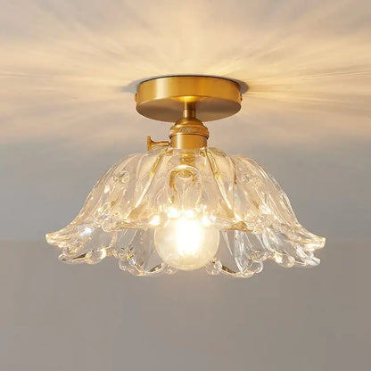 A clear glass flower-shaped ceiling light with brass copper led base for dining room chandelier use