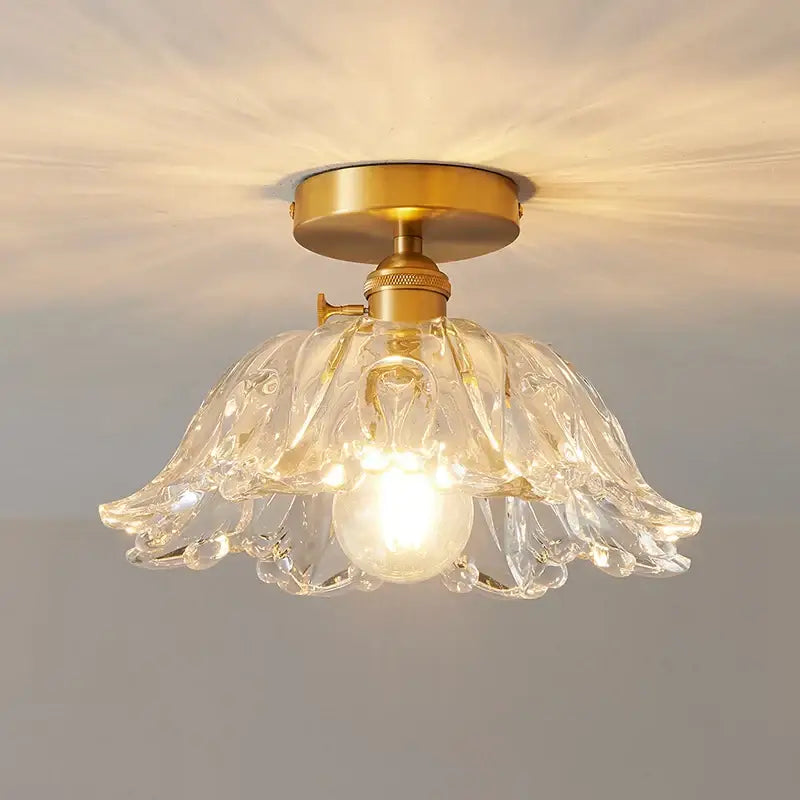 A clear glass flower-shaped ceiling light with brass copper led base for dining room chandelier use