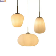 Three warm-toned ribbed glass copper led pendant chandelier lights hanging from slender rods for dining room use