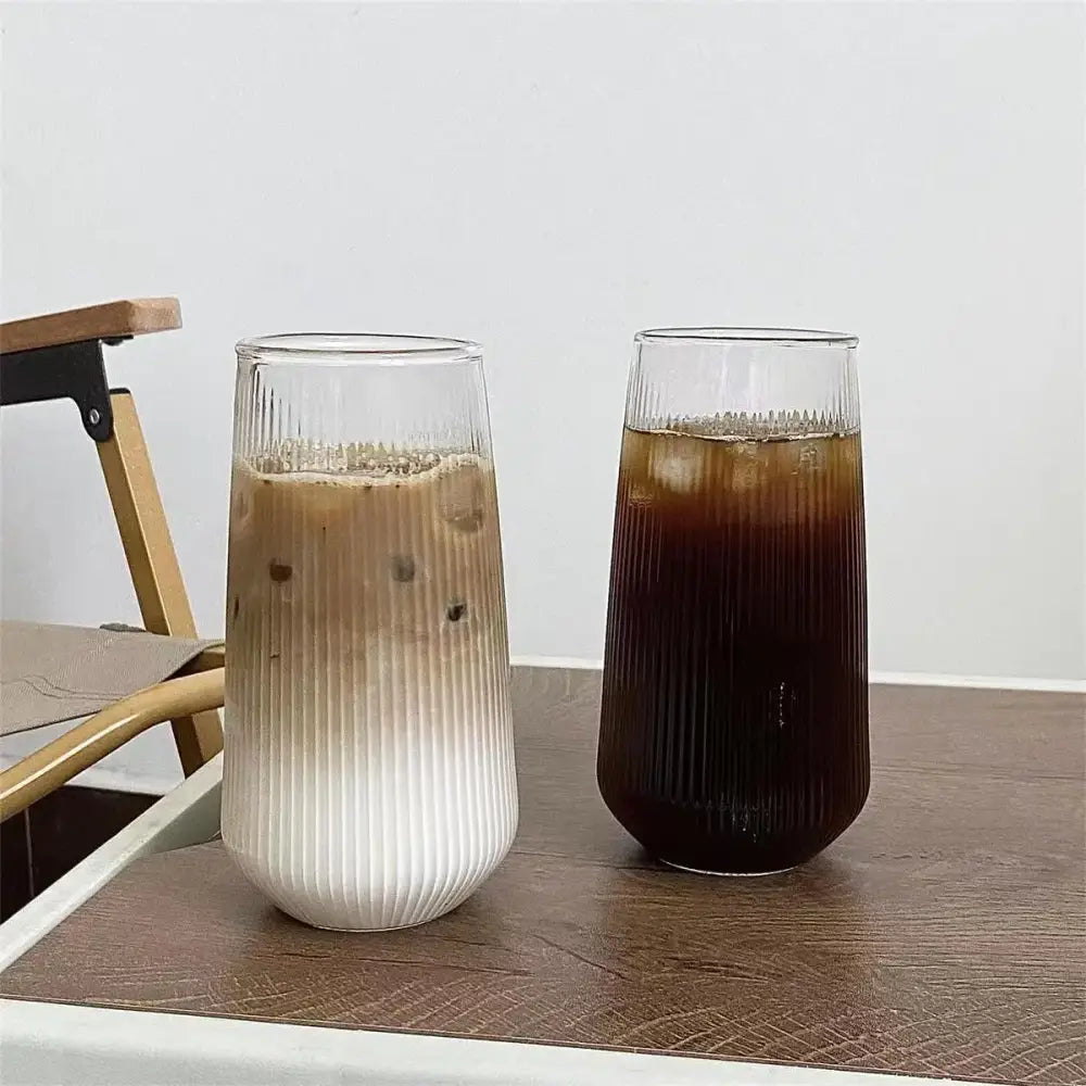 Two tall ribbed glass cups with frosted white lower half in a glass cup set for kitchen dining use