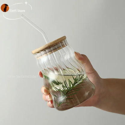Clear ribbed glass cup with bamboo lid and lip straw filled with water and fresh rosemary for decorbites glass cup use