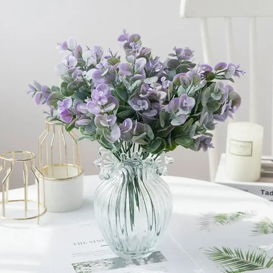 A clear ribbed glass eucalyptus leaves vase holding artificial lavender and green eucalyptus leaves for living room decor