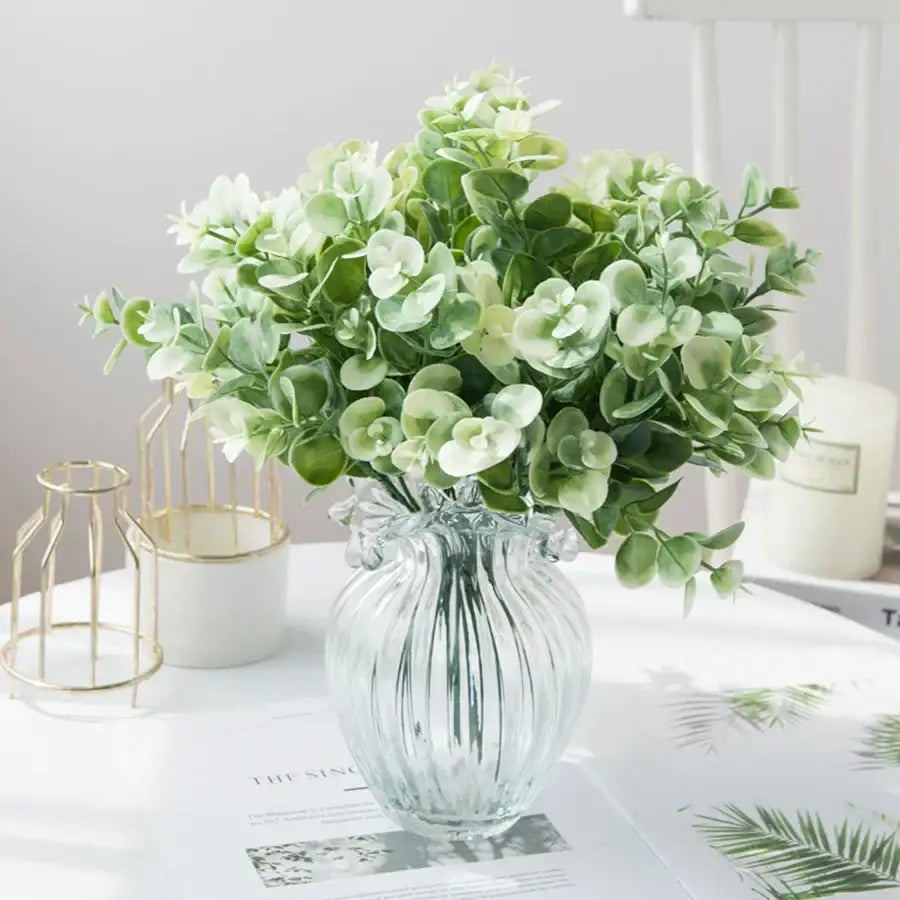 A clear ribbed glass eucalyptus leaves vase with green and pale white artificial eucalyptus for lavender living room decor