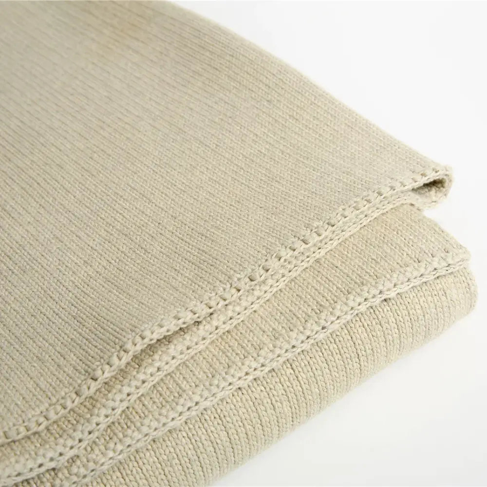 Beige ribbed organic cotton weighted blanket with textured woven pattern and neatly stitched edges for bedroom sleep