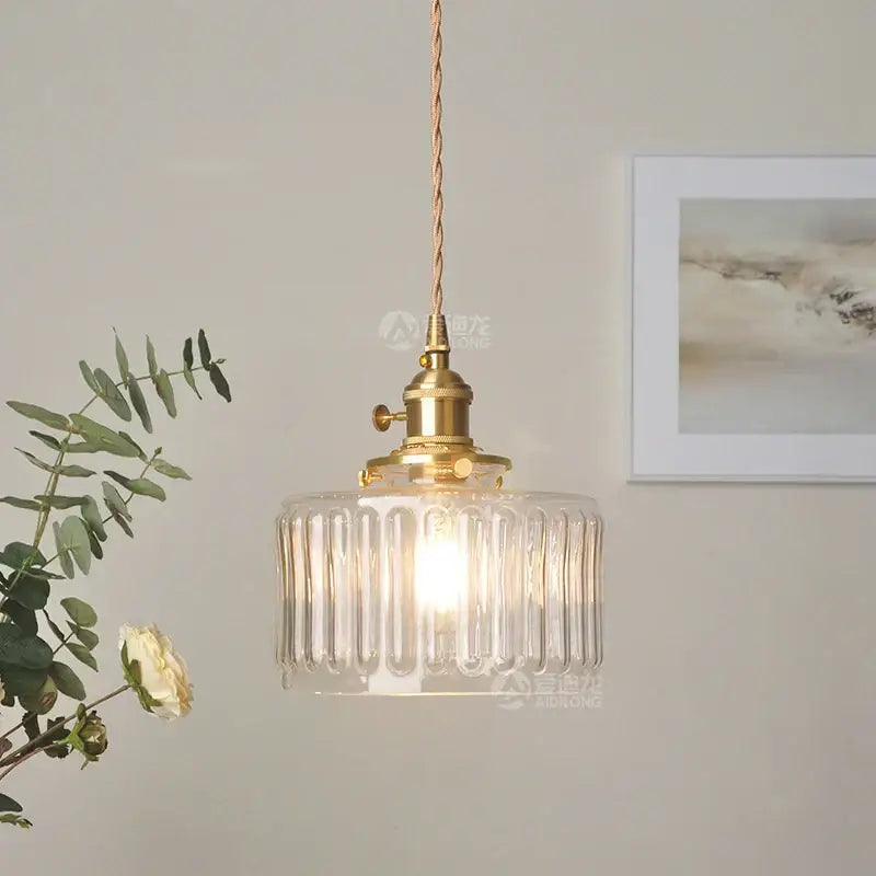 Vintage-style pendant light featuring a clear ribbed green glass pendant with brass hardware for bedroom use
