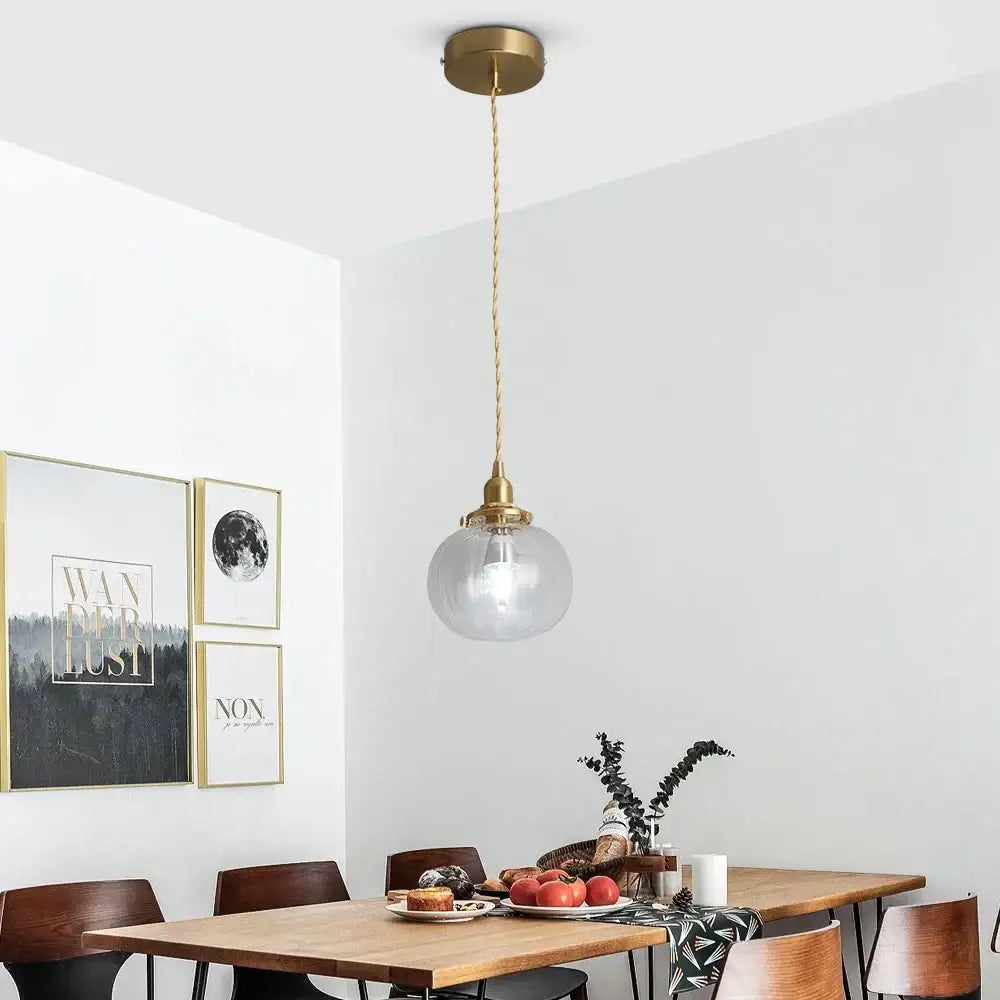 Modern brass pendant light with clear glass globe shade and twisted cord paired with decorbites green pendant chandelier