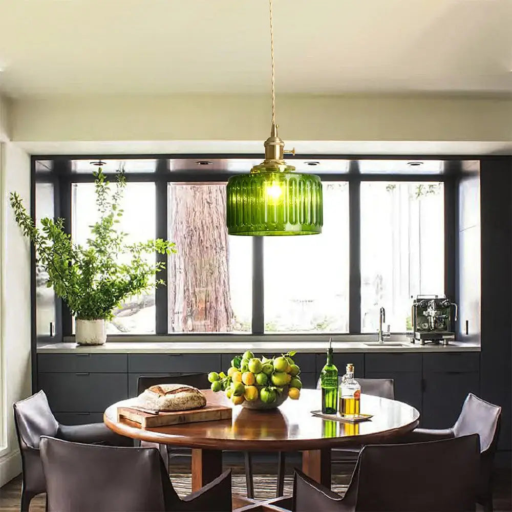 A vibrant green ribbed glass pendant light with brass hardware hangs above the dining table decorbites green pendant