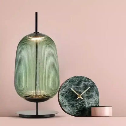 A sleek ribbed green glass table lamp with a black metal base for bedroom lighting decorbites green red