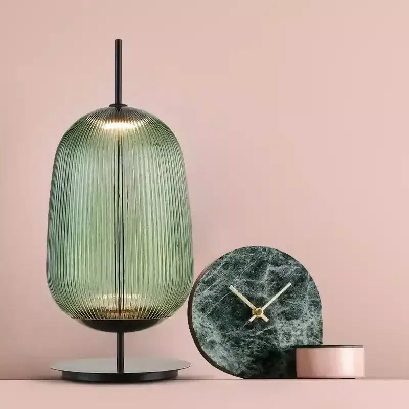 A sleek ribbed green glass table lamp with a black metal base for bedroom lighting decorbites green red