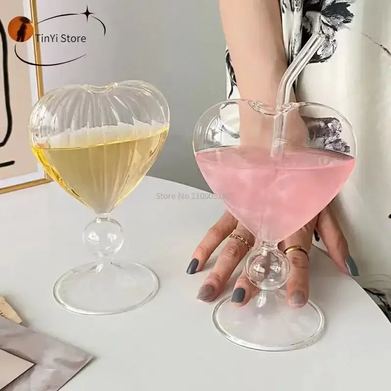 Clear heart-shaped glass mugs with ribbed detailing and bulbous stem filled with yellow and pink drinks decorbites heart love