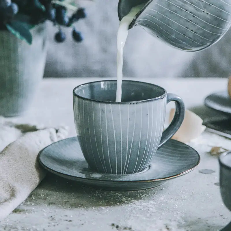 Gray ribbed matte ceramic coffee cup set with subtle speckled glaze and matching saucer for dining room use