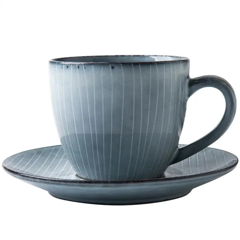 A sleek matte-finished blue ceramic coffee cup with subtle vertical ridges and matching saucer in coffee cup set