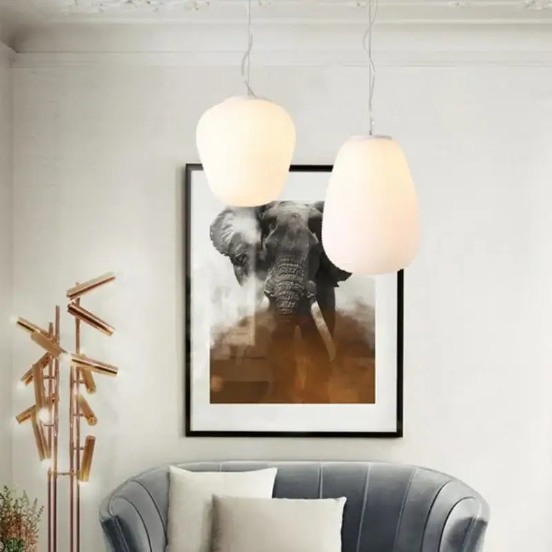 Two off-white ribbed glass cocoon pendant lights hang from the ceiling ideal for dining room decorbites pendant light