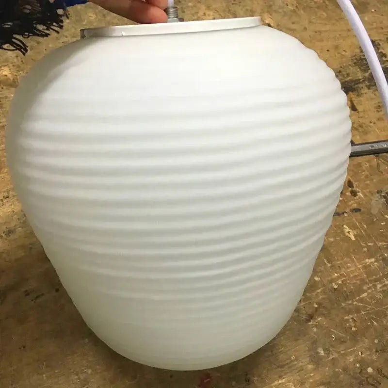 White ribbed glass whorl pendant light with metallic top and cord for kitchen decor