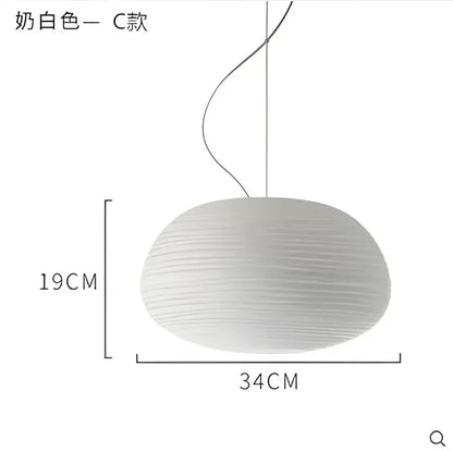 A soft creamy white glass whorl pendant light with ribbed texture and sleek curved cord for kitchen decor