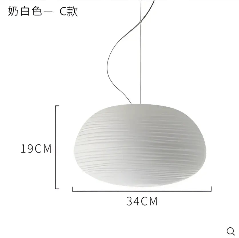 A soft creamy white glass whorl pendant light with ribbed texture and sleek curved cord for kitchen decor