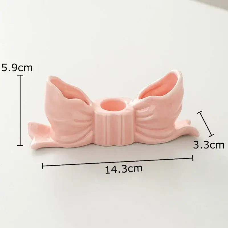 A delicate ribbed pink ceramic bowknot candle holder with two flared openings and central hole for decorbites decorbites bowknot candle