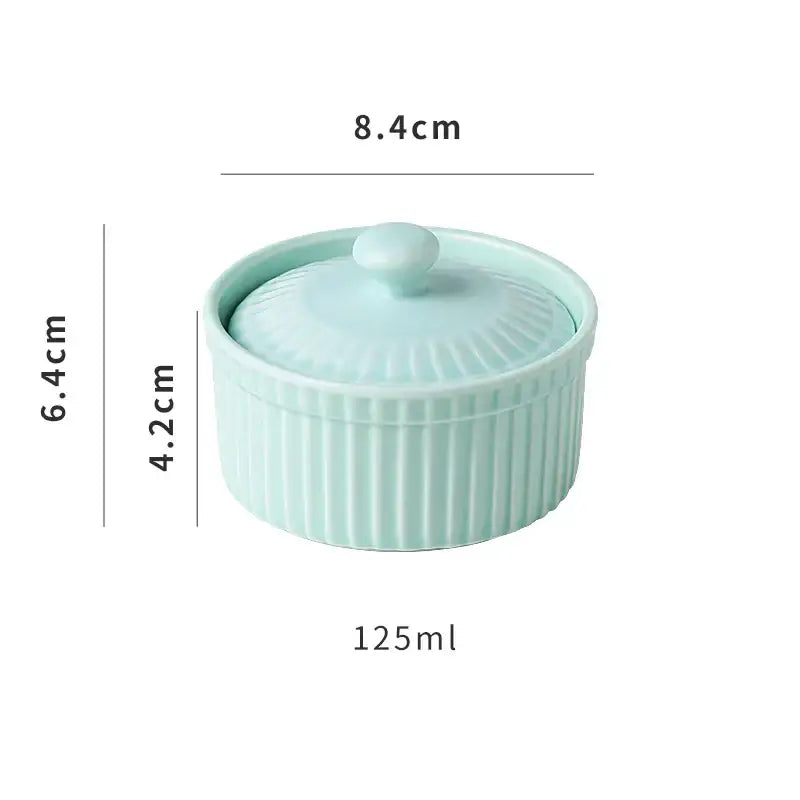 A light mint green decorbites ceramic dessert bowl with vertical ribs and a matching lid with knob