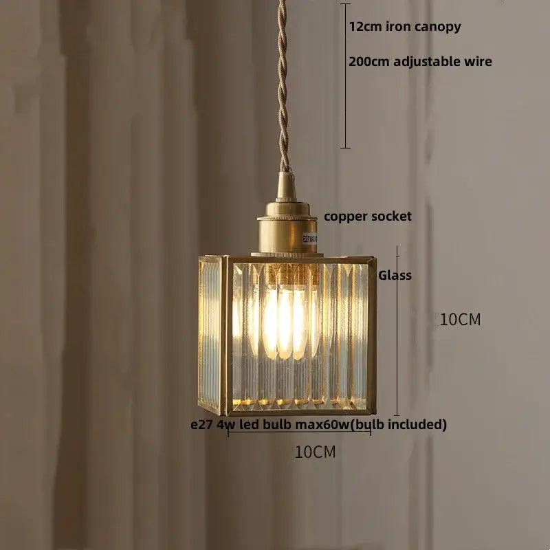 A brass-framed rectangular pendant light with ribbed teal blue glass panels and a copper socket for dining room decorbites blue glass led lighting
