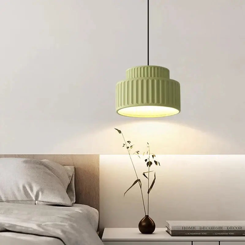 A modern two-tiered pendant light with matte sage green cream resin led finish and vertical ridged texture for dining room decorbites