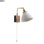 White ribbed ceramic led wall lamp with brass arm and wooden base featuring pull chain switch for bedroom mirror light