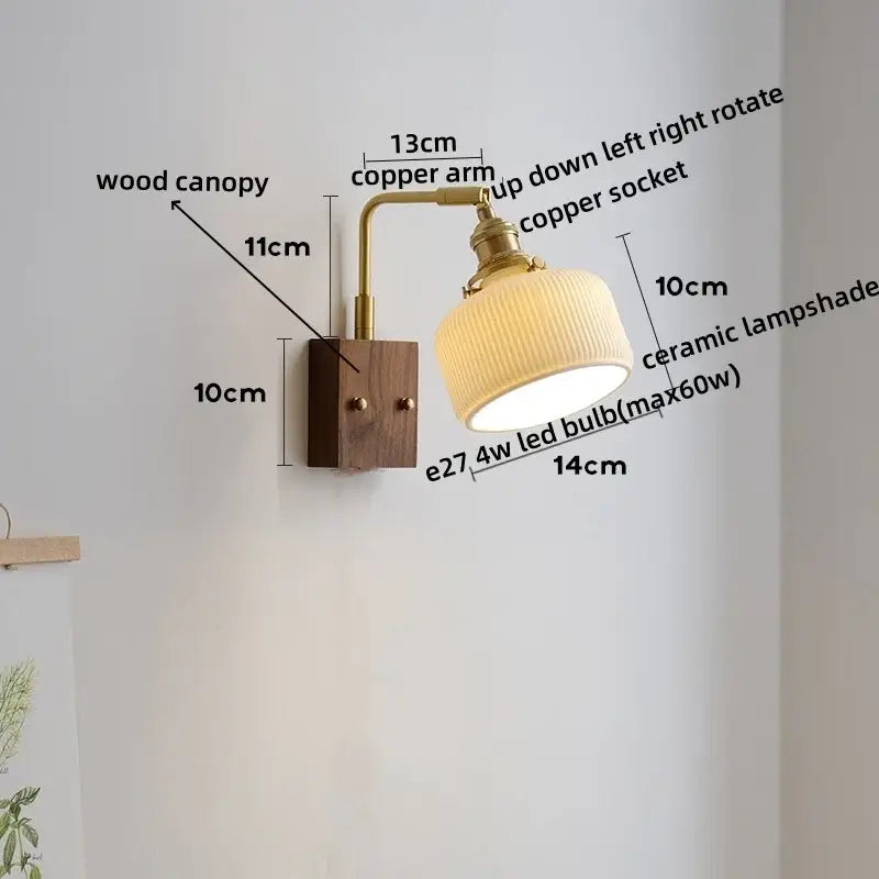 A warm-toned brass-finished copper led wall lamp with a ribbed cream ceramic shade and wooden canopy base for bedrooms