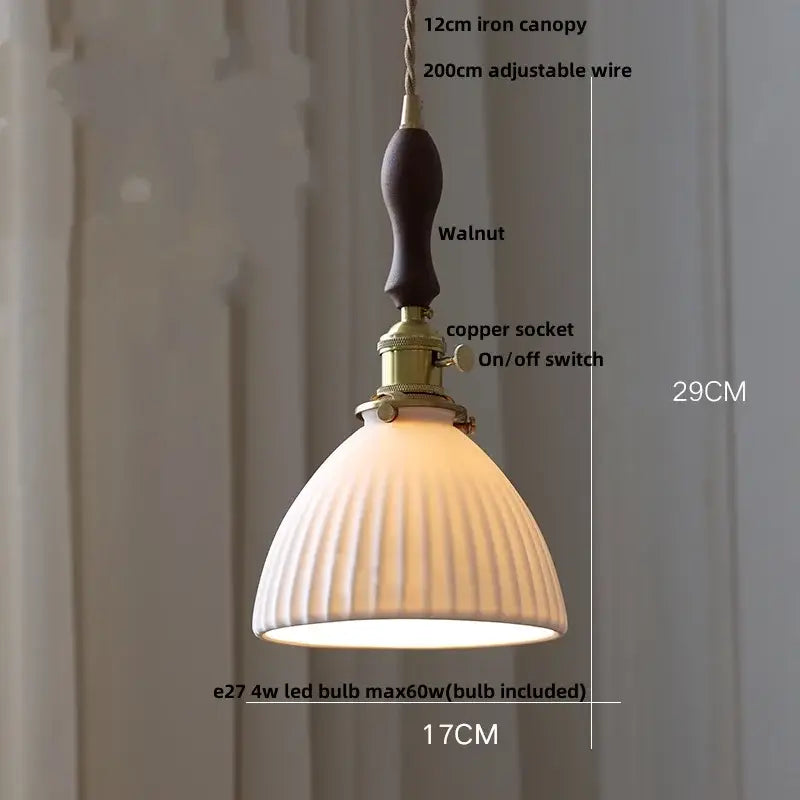 Ribbed white ceramic pendant light fixture with warm tones, walnut iron canopy, and brass hardware for kitchen use