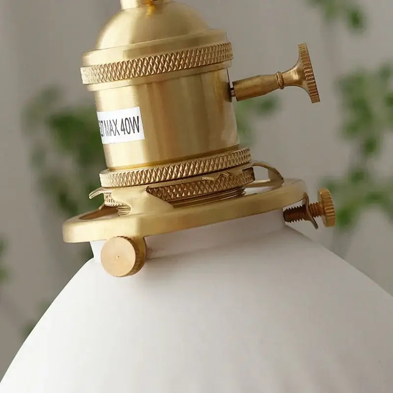 Brass-finished vintage pendant light fixture with ribbed white ceramic shade and brass knob switch for kitchen use