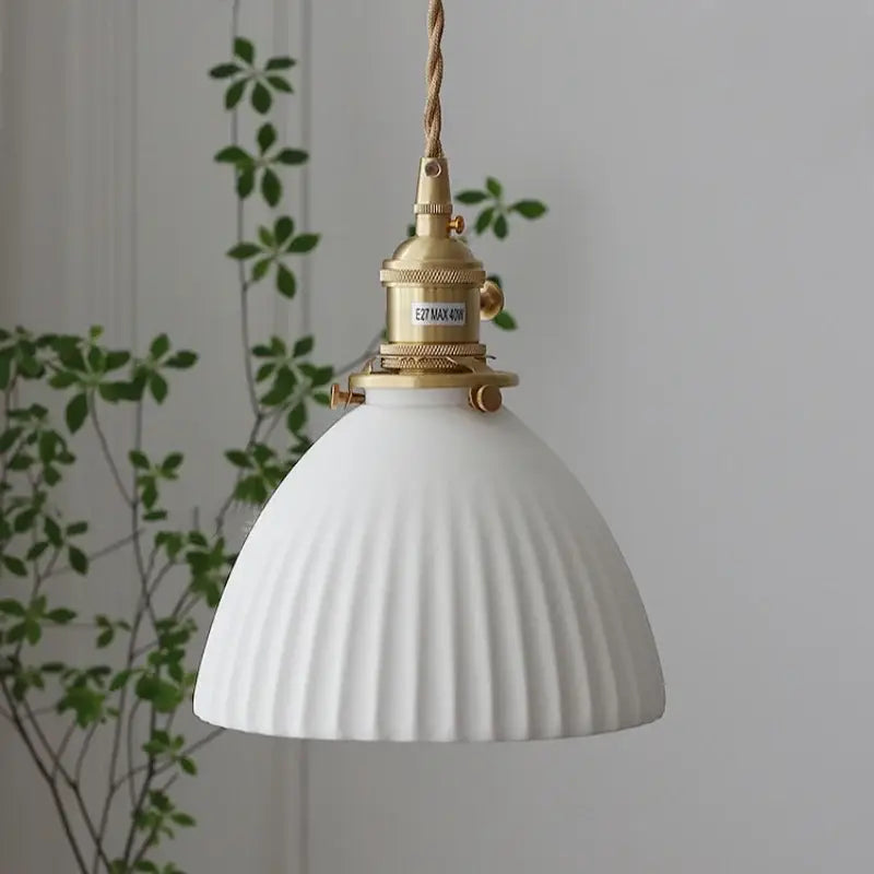 Ribbed white ceramic pendant light fixture with brass-finished metal and twisted rope cord for kitchen use