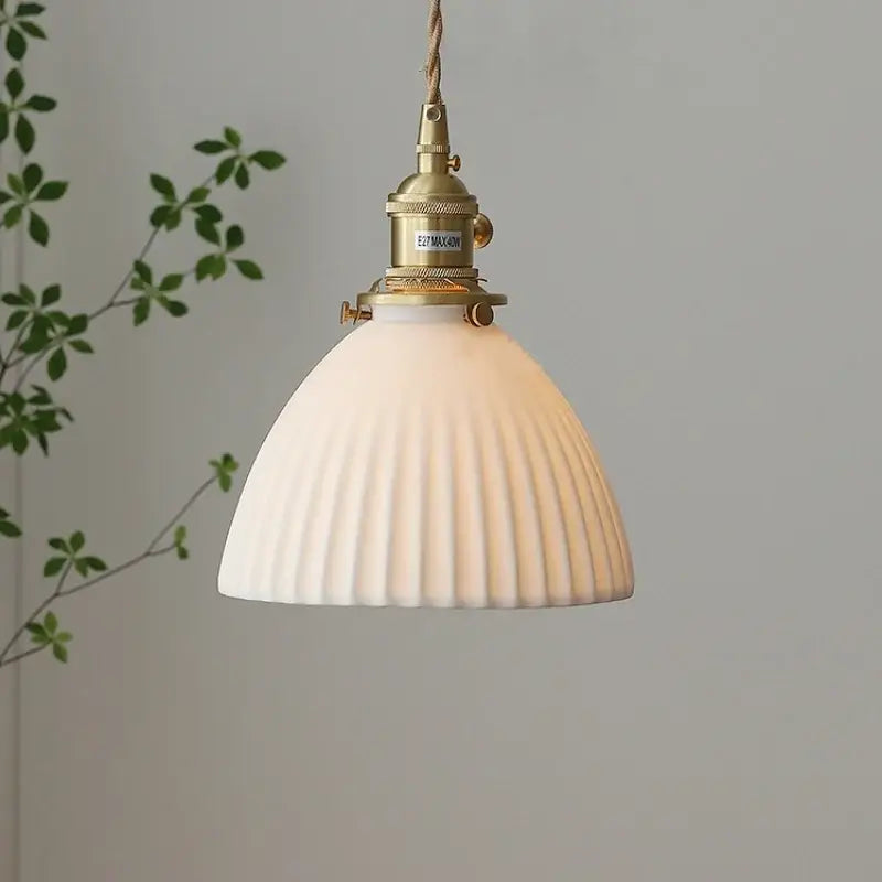 White ribbed ceramic pendant light fixture with brass knob switch and braided cord for kitchen lighting