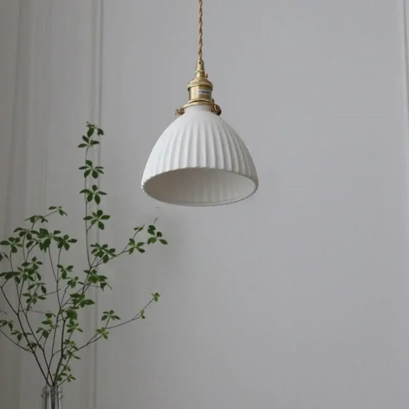 White ribbed ceramic pendant light fixture with brass knob switch and twisted copper cord for kitchen lighting