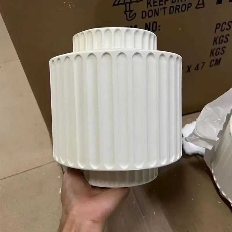 Cream white resin wall sconce with vertical fluted ridges and tiered cylindrical design for bedroom decorbites cream white decor