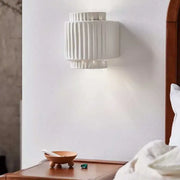 White ceramic wall sconce with vertical ridged texture in creambites cream white resin for bedroom decor