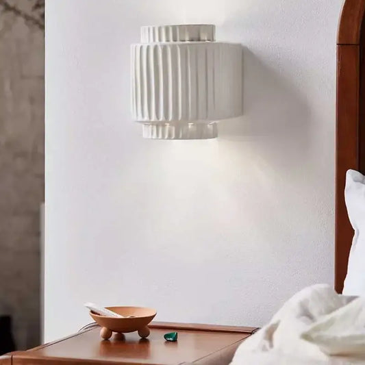 White ceramic wall sconce with vertical ridged texture in creambites cream white resin for bedroom decor